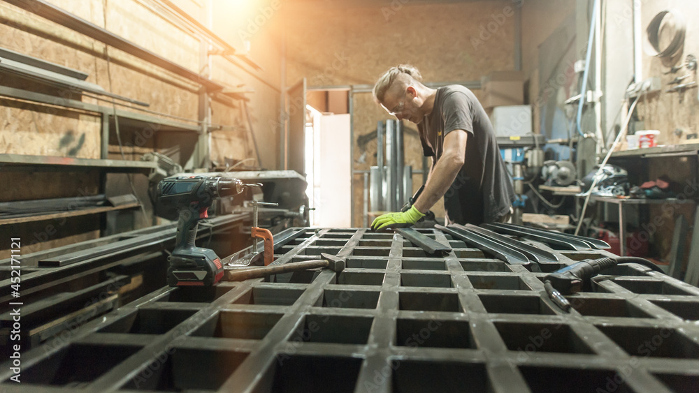 Craftsman worker working on steel structure in factory Craftsman worker working on steel structure in factory