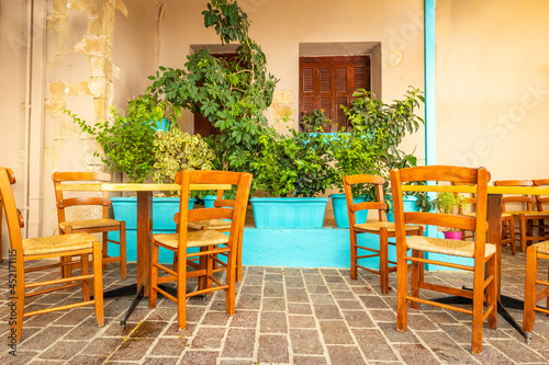 Tables and chairs in an atmospheric place with a nice atmosphere, among greenery, blue pots and medieval walls