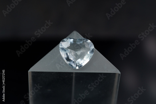 Natural blue aquamarine on a stand on a black background