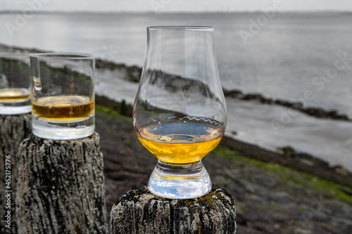 Cuadro en lienzo Tasting of dram single malt scotch whisky on seashore in Scotland, old wooden po