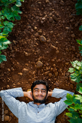Young Indian farmer resting or sleeping in a cotton field