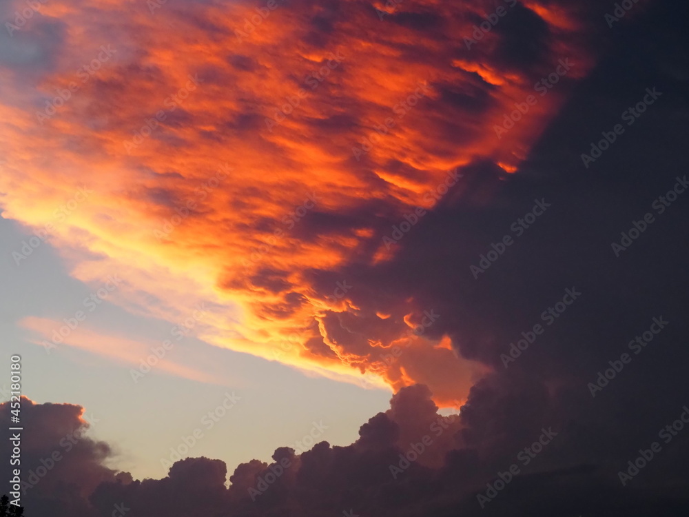 Thunderstorm at sunset produced deep red colors on the underside of the cumulonimbus anvil. 