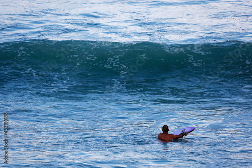 Homme en bodyboard devant une vague à l'ocean photo