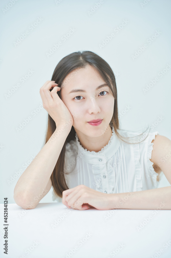 肘をつくポーズをする若い女性