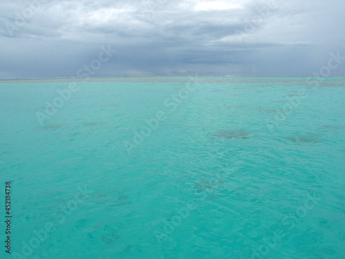 Moorea, French Polynesia: dark rain season clouds over blue lagoon forecast approaching tropical storm,