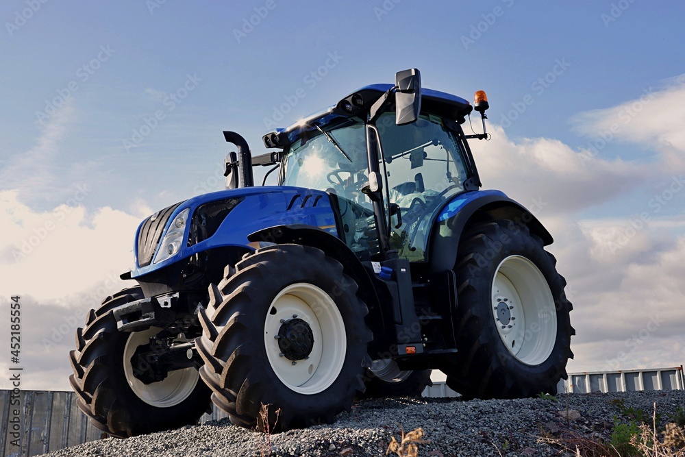 Fototapeta premium New farm tractor on a blue colour.