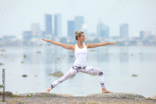 young woman exercising in the morning by the sea