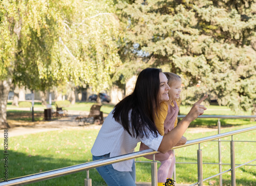 adult woman having fun with her child daughter in green park