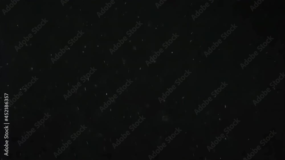 Drifting real dust isolated on a black background. Filmed spore particles with selective focus floating in the air. Cinematic overlay as organic concept template for a macro virus, pollen, vapor