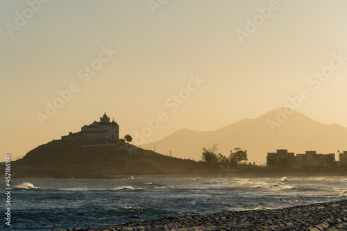 Sunset at Saquarema Beach in Rio de Janeiro, Brazil. Famous for waves and surfing. Church on top of the hill.