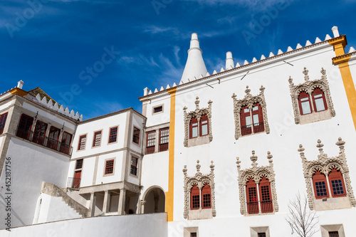 View of the facade of the National Palace of Sintra (Palacio Nacional de Sintra) with the Manueline style windows, in Sintra, Portugal.