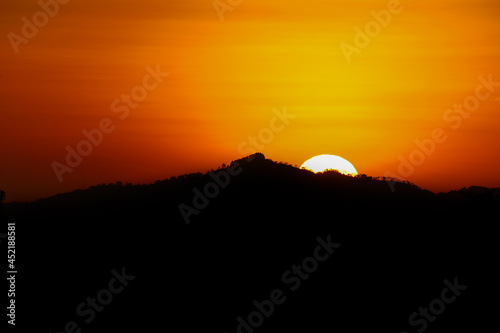 sunset in the mountains with hiding sun