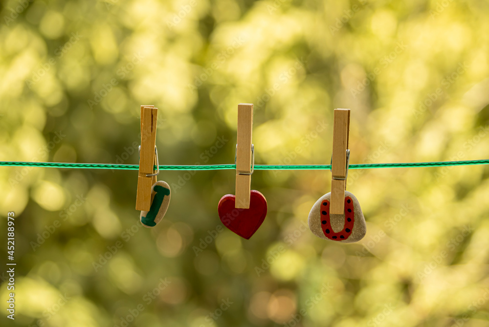 Red heart and colorful stones on clothesline Red heart and colorful stones on clothesline