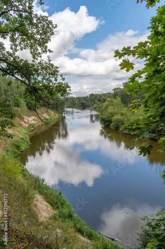 Fototapeta Naklejka Na Ścianę i Meble -  Wijąca się rzeka Bug, niebieskie niebo z chmurami, zielone lasy, lato