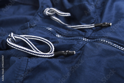Blue zipper on a blue windbreaker jacket. 