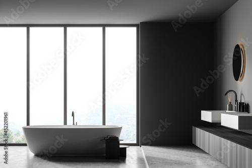 Dark bathroom interior with bathtub  panoramic window  carpet  concrete floor