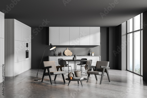 Corner of panoramic grey kitchen with seating area and round dining table