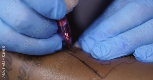 Tattoo artist working with client