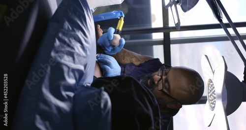 Tattoo artist working with client