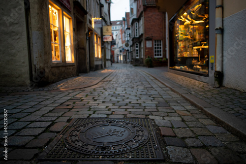 small street with beautiful pavement and ancient buildings in the famous tourist pedestrian area "Schnoor" in Bremen, Germany in the evening