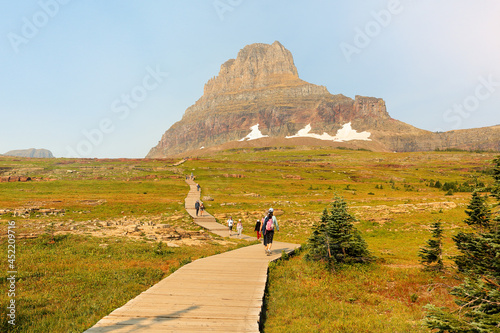 Overview of Logan Pass with tourist walking at sunrise. Logan Pass is located along the Continental Divide in Glacier National Park, in the U.S. state of Montana. photo