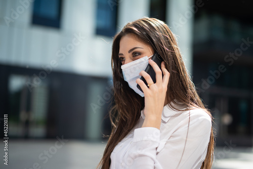 Masked woman talking on the phone, covid and coronavirus concept