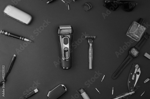 Men's casual accessories on black background. Electric shaver and disposable razor. Kit for removing body hair. photo