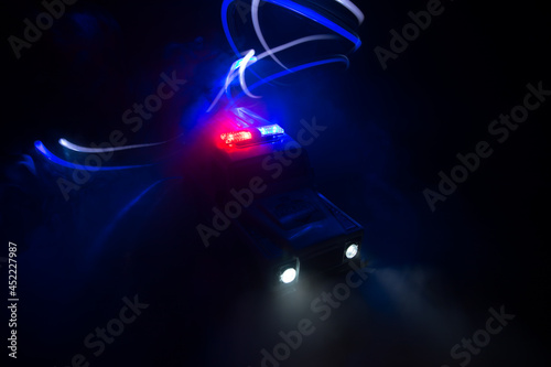 Police car chasing a car at night with fog background. 911 Emergency response police car speeding to scene of crime. Selective focus © zef art
