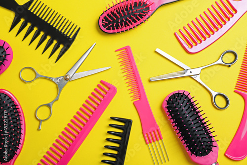 Flat lay composition with professional scissors and other hairdresser s equipment on yellow background. Haircut tool
