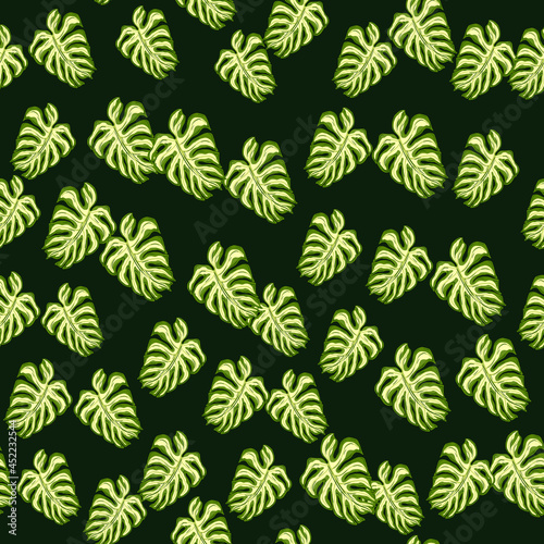 Decorative foliage seamless pattern with random palm leaf monstera elements. Dark background.
