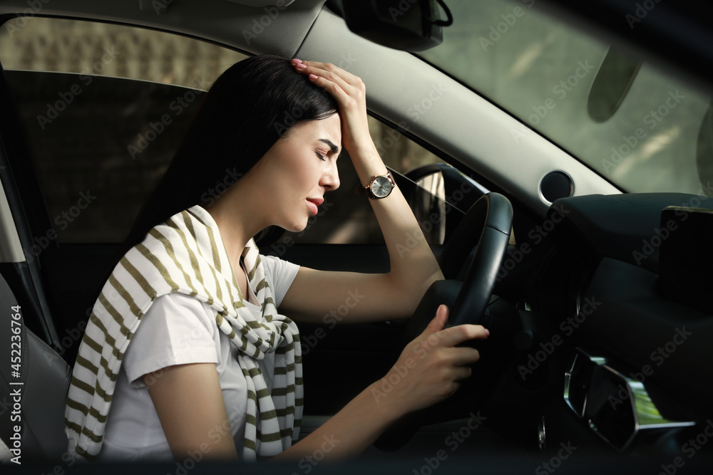 Stressed young woman driver's seat of modern car