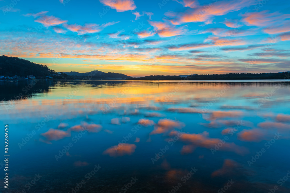 Fototapeta premium Sunrise waterscape with high cloud and reflections
