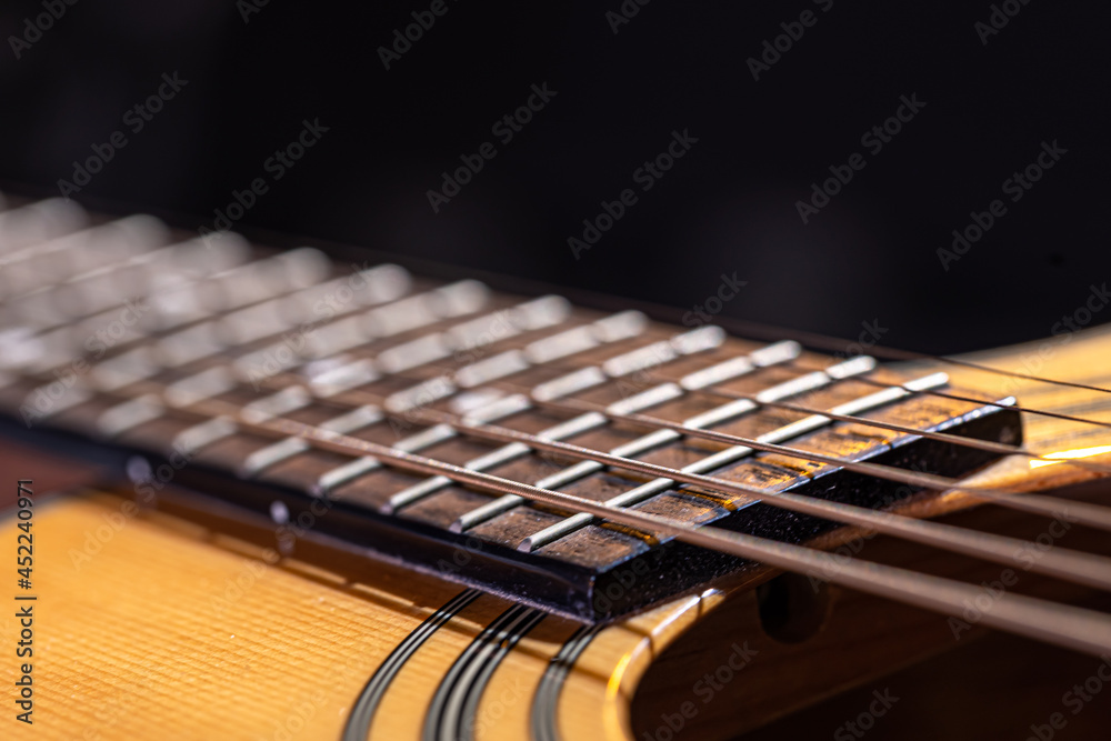 Fototapeta premium Close-up of a guitar fretboard on a black background.