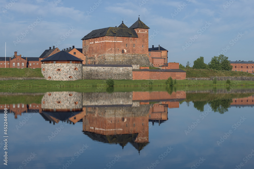 View of the ancient fortress-prison of the city of Hameenlinna on the shores of  Vanajavesi lake in the early July morning. Finland
