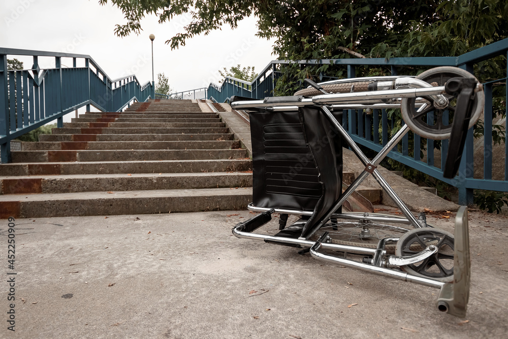 The concept of a wheelchair on the stairs turned over, disabled, full life, paralyzed. Problems for the disabled person. The concept of a wheelchair on the stairs turned over, disabled, full life, paralyzed. Problems for the disabled person.