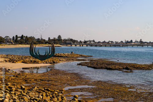 Kurnell National Park Sculpture on the rocky foreshore with the bay in the background. No people, space for copy. photo