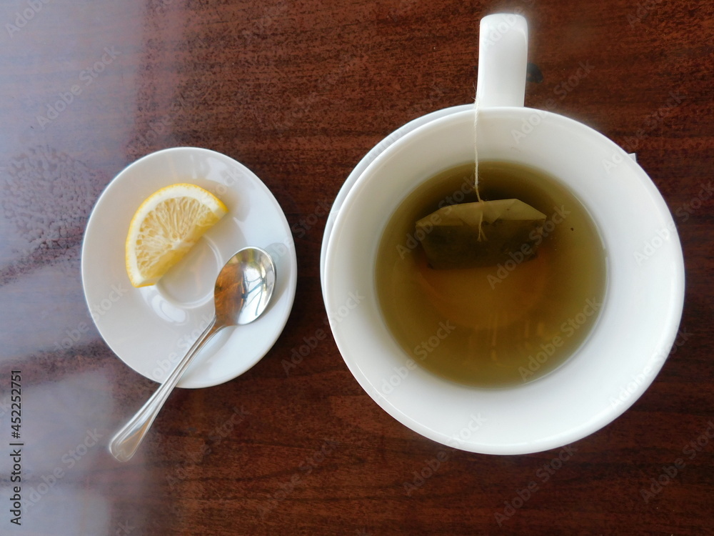green tea in a white cup on a wooden table. green tea in a white cup on a wooden table.