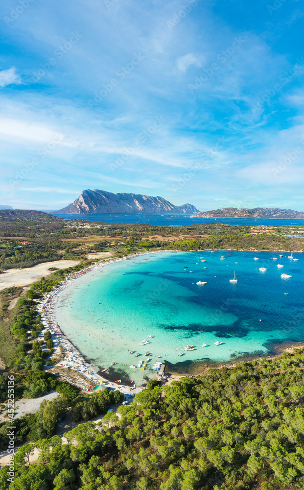 View from above, stunning aerial view of Cala Brandinchi beach with its beautiful white sand, and crystal clear turquoise water. Tavolara island in the distance, Sardinia, Italy.