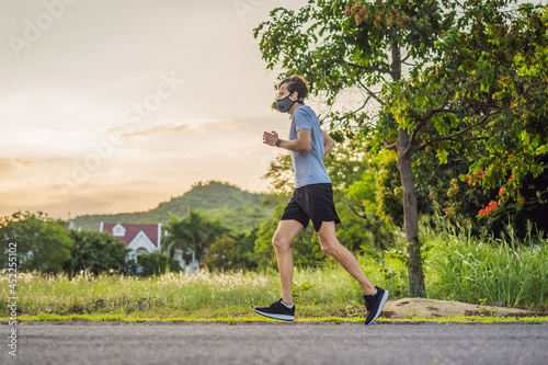 Runner wearing medical mask, Coronavirus pandemic Covid-19. Sport, Active life in quarantine surgical sterilizing face mask protection. Outdoor run on athletics track in Corona Outbreak