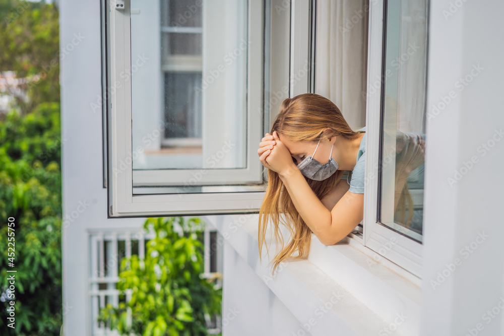 Extremly tired woman looking out the window, home alone. self-isolation at home, quarantine due to pandemic COVID 19. Mental health problems in self-isolation at home, quarantine, isolation, stay at