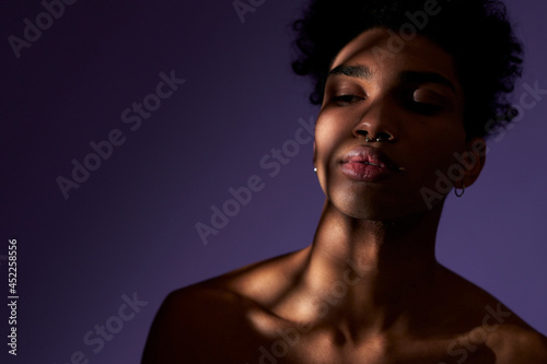 Close up portrait of young latin american man with eyes closed in shadow. Sensitive and sensual face