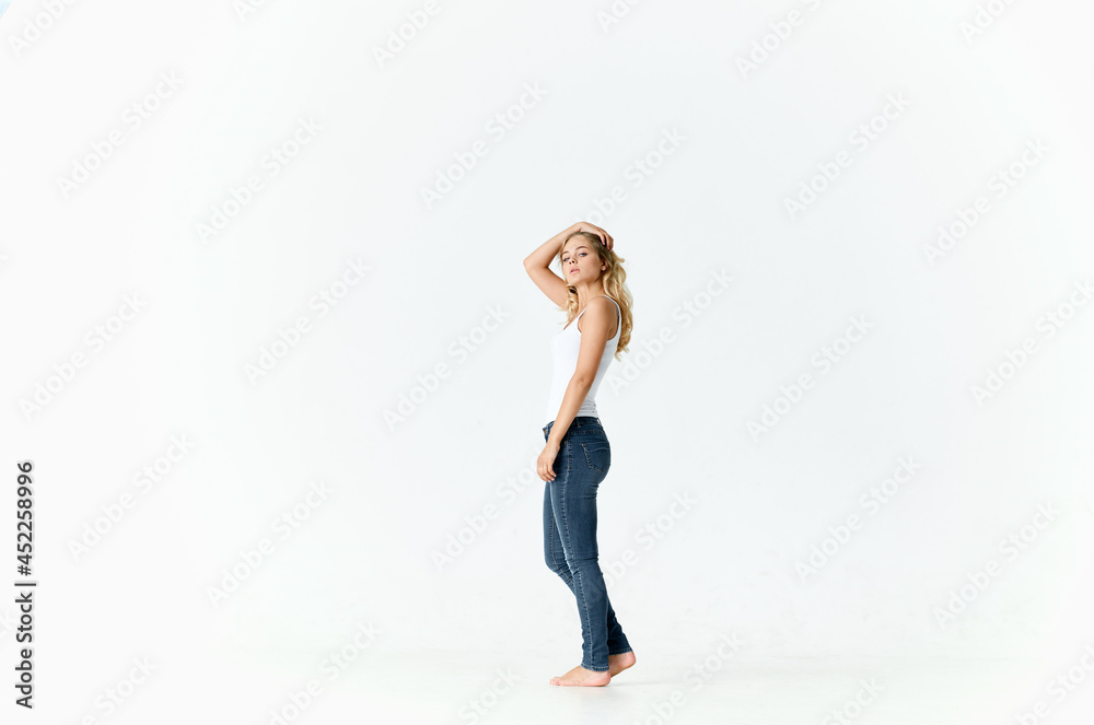 woman barefoot in jeans movement positive emotions light background woman barefoot in jeans movement positive emotions light background
