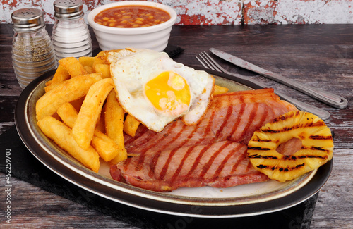 Grilled gammon egg and chips meal with baked beans and pineapple fruit ring