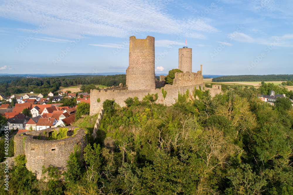 Ruin of medieval Münzenberg castle in Hesse, Germany. Built in 12th century, one of the best preserved castles from the High Middle Ages in Germany. Summer, sunset light, aerial view