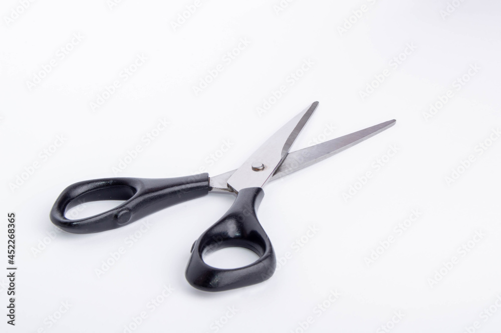open scissors with black handle on white background side view open scissors with black handle on white background side view