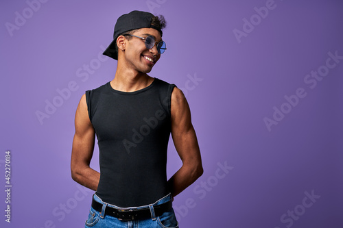 Portrait of transgender male in black t-shirt and blue jeans. Latino trans gender model posing