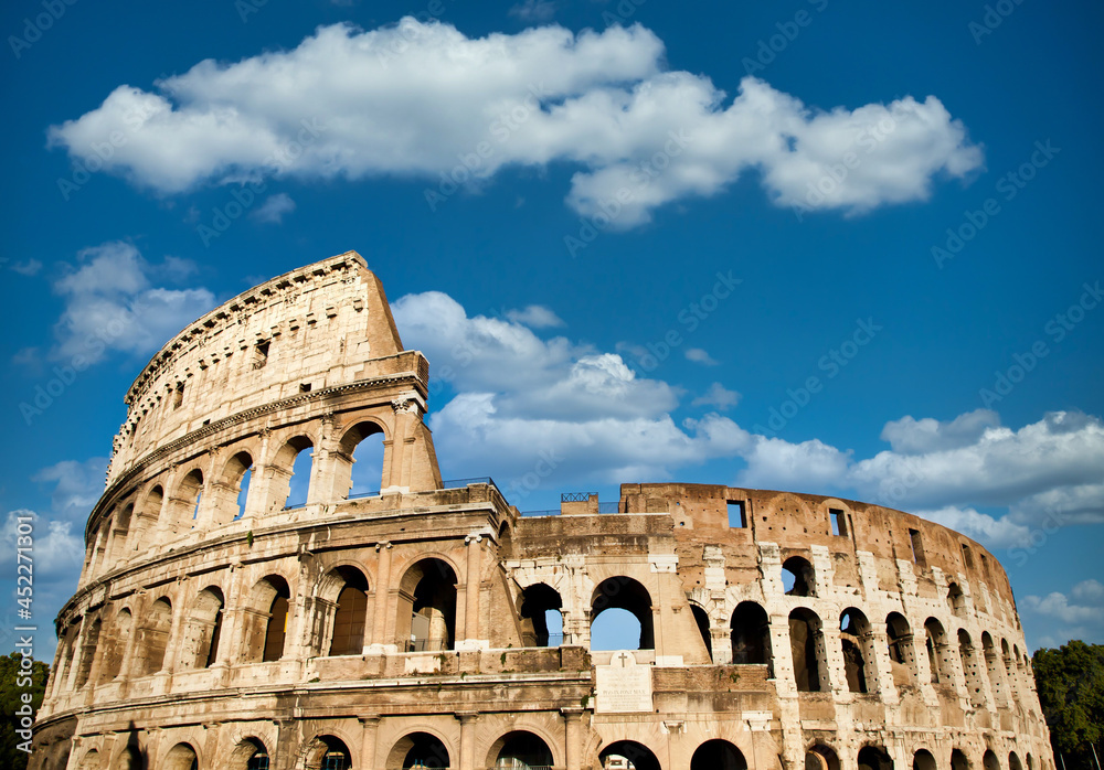 Rome, Italy. Arches archictecture of Colosseum exterior with blue sky background and clouds.
