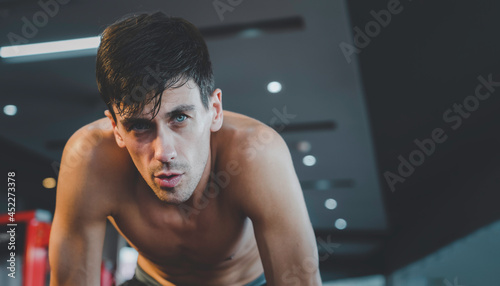 Portrait of handsome caucasian athlete male workout and tired in fitness gym with copy space