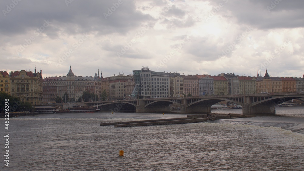 Natural replenishment water balance territory. Bridge over river. Water movement. View embankment city Prague in rain. The houses are on the coastline. 