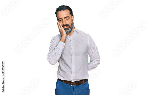 Middle aged man with beard wearing casual white shirt thinking looking tired and bored with depression problems with crossed arms.
